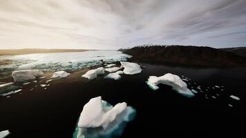 Icebergs floating serenely in a calm Arctic waterscape during sunset video