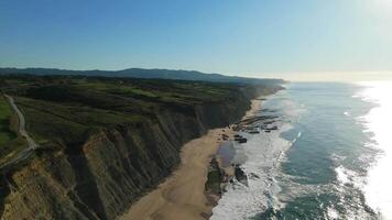 magoito playa y acantilados en soleado día. atlántico océano, Portugal. aéreo vista. Moviente adelante video