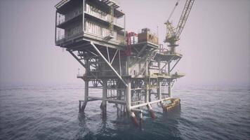 Old oil platform standing in calm waters during misty weather early in the day video