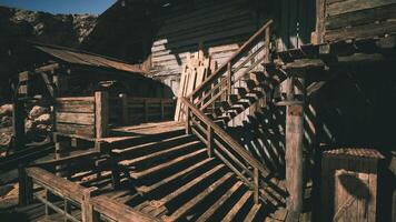 Rustic wooden staircase leading to a weathered structure in a desert area video