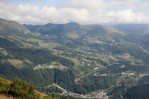 Mountain valley panorama, village, road, clouds, travel brochure photo