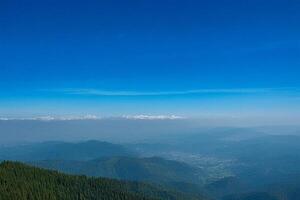 Mountaintop panoramic view distant hazy valley, clear sky photo