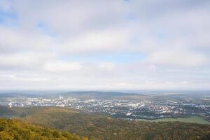 Hilltop autumn city view, hazy sky, distant buildings, travel brochure photo