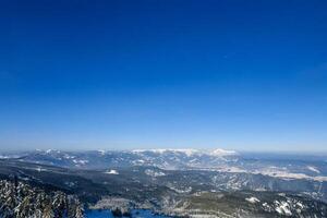 Snowy mountain range winter landscape, clear sky, aerial view photo