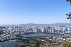 A view of the city from a hill overlooking a lake photo