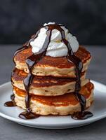 Delicious pancakes with chocolate sauce and whipped cream. photo