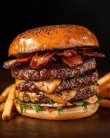 Juicy triple decker bacon cheeseburger with crispy fries photo