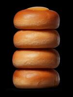Stack of four honey glazed buns on black background photo