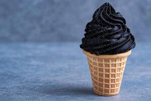 Black ice cream cone with glitter on a blue background photo