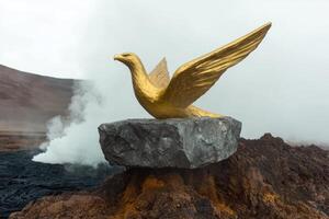 Golden bird statue on volcanic rock, steam rising in background photo