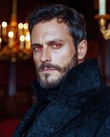 Mysterious man with red eyes in a dark coat photo