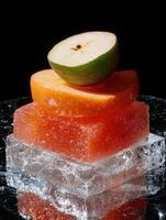 Sliced apples and pears on ice cubes, close up shot photo