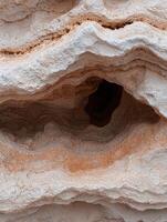 Close up of a textured rock formation with a cave like opening photo
