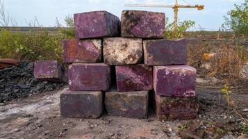 Stack of weathered purple concrete blocks in a construction site photo