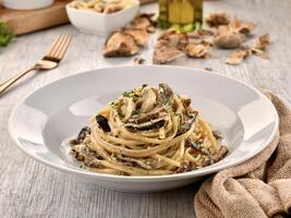 CREAMY TRUFFLE PASTA with mushroom served in dish isolated on wooden table side view of italian fast food photo
