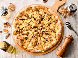 Mushroom and Truffle Pizza topping with Fresh mushrooms, melted cheese, and a drizzle of truffle oil served on wooden board top view of italian fast food photo