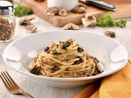 LINGUINE AL PROSCIUTTO E TARTUFO served in dish isolated on wooden table side view of italian fast food photo