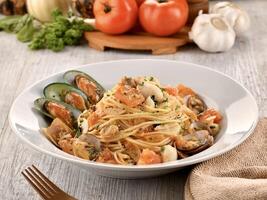 Seafood Spaghetti served in dish isolated on wooden table side view of italian fast food photo