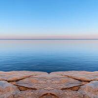 Tranquil ocean view from a rocky shore at sunset photo
