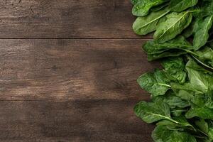 Fresh spinach leaves on rustic wooden background photo