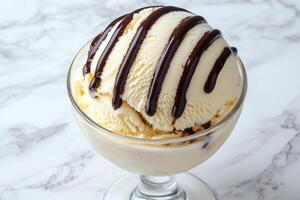 Vanilla ice cream with chocolate syrup in a glass bowl photo