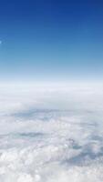 Fluffy clouds under a serene blue sky at high altitude. Ethereal aerial view, peaceful horizon, dreamy atmosphere, scenic cloudscape, tranquil environment, and minimalist beauty. video