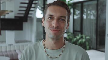 Young adult man looking at camera with calm and confident demeanor self-assurance emotional state. Caucasian person maintaining composed and assured expression while looking into camera. video