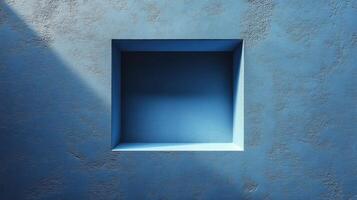 Minimalist architectural detail of a sunlit square niche in textured blue wall. photo