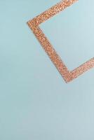 Minimalist geometric composition with a glittery copper triangle on a pastel blue background. photo