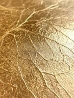 Abstract close-up of textured gold surface with intricate cracks and veins. photo