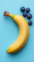Fresh banana and blueberries arranged on a vibrant blue background. photo