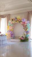 Elegant event decor featuring a pastel balloon arch complemented by flowers in a sophisticated venue setting. photo