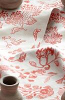Elegant floral-patterned fabric with terracotta accents draped artistically. photo