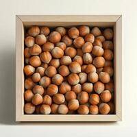 A wooden box filled with fresh, brown hazelnuts arranged neatly against a light background. photo