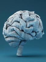 Artistic brain sculpture crafted from folded newspaper on a teal background. photo