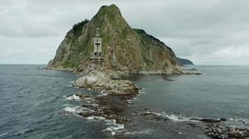 Lighthouse on rocky island surrounded by the sea video