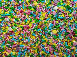 Colorful seamless pattern of candies of different colors and shapes. Sugar confectionery sprinkles as horizontal background. photo