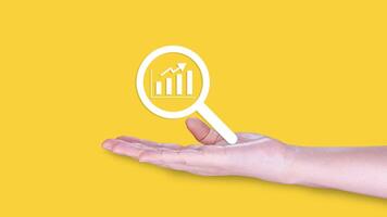 Analyze Market Trends with Precision, Businessman Examining Financial Graphs through Magnifying Glass for Strategic Investment Decisions photo