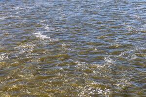 Rough flow of foaming water in the river, close-up, background. photo