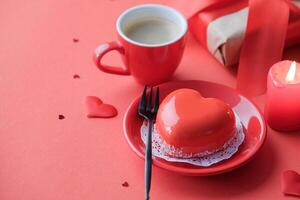 red heart cake and coffee in small cup for valentines day on red background , copy space photo
