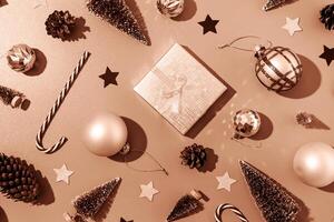 Mocha Mousse - color of the year 2025. christmas pattern with decorations, frame made of gifts, candy canes, balls and trees on gray background, flat lay photo