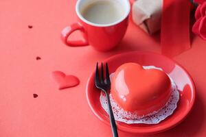 red heart cake and espresso in small cup for valentines day on red background , copy space photo