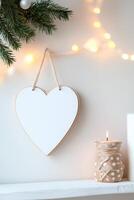 Photo frame of heart shape for mockup design hanging on the wall on light wall background.