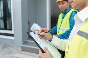 inspector engineer and owner project is inspecting construction and quality assurance new house. Engineers or architects or contactor work to build the house before handing it over photo