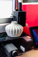 Four heads 3d printer, four extruders with an object on the tray, pla filament, indoors photo