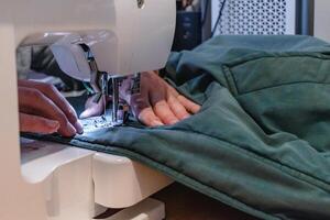 Man using a sewing machine with a garment, for repair work, customization, creation, upcycling, hand photo