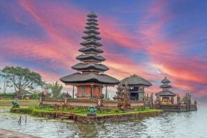 Traditional Balinese temple with tiered pagoda roofs against colorful sky photo