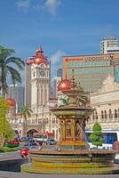 Historic clock tower and fountain in central Kuala Lumpur at daytime photo