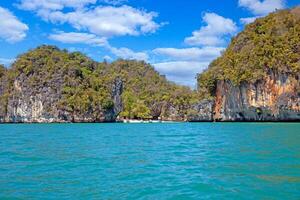 Limestone cliffs and blue sea in Krabi Thailand with a small beach photo