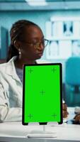 Vertical Medical consultation featuring a physician and a patient next to copy space mockup on wellness and recovery, expert feedback in a clinic. African american women discussing about medicine. Camera B. video